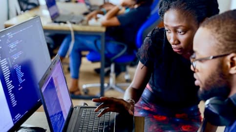 Developers reviewing code together on dual monitors